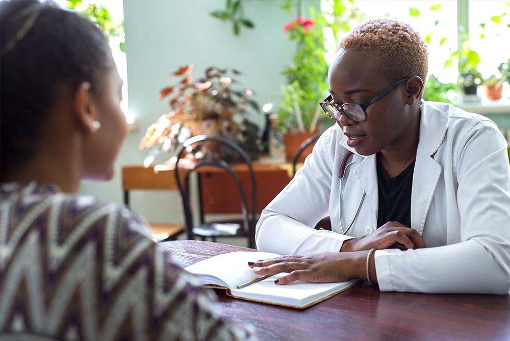 Doctor at a table going over paperwork with a Patient