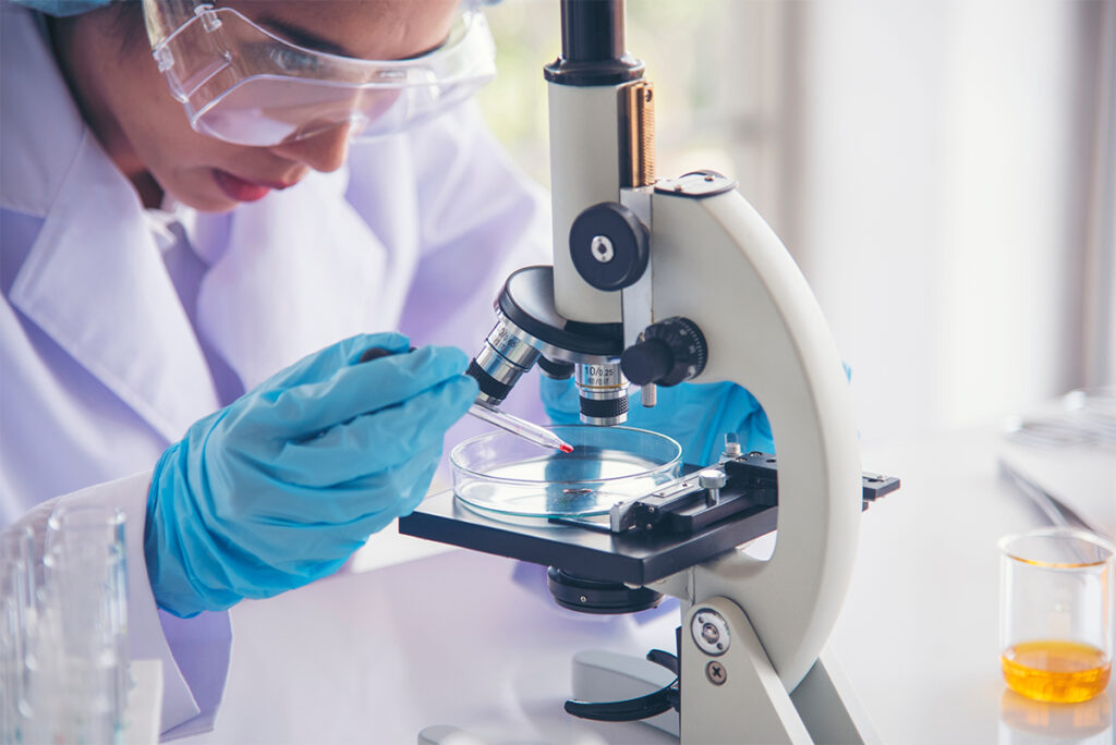 Scientist looking at a slide under a microscope