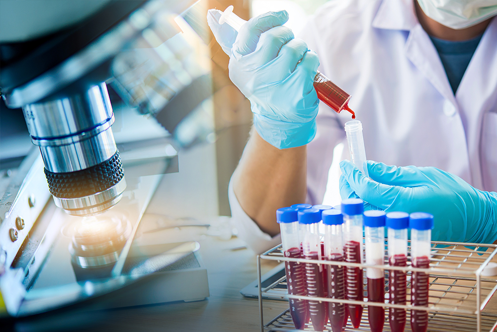 Microscope and a scientist working with blood samples and test tubes