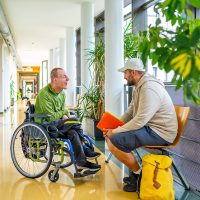 ALS patient in a wheelchair with a caretaker